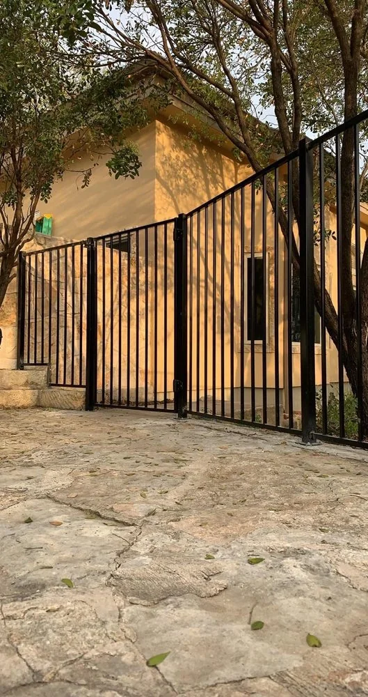 Black ornamental steel fence on a Central Texas hill country property