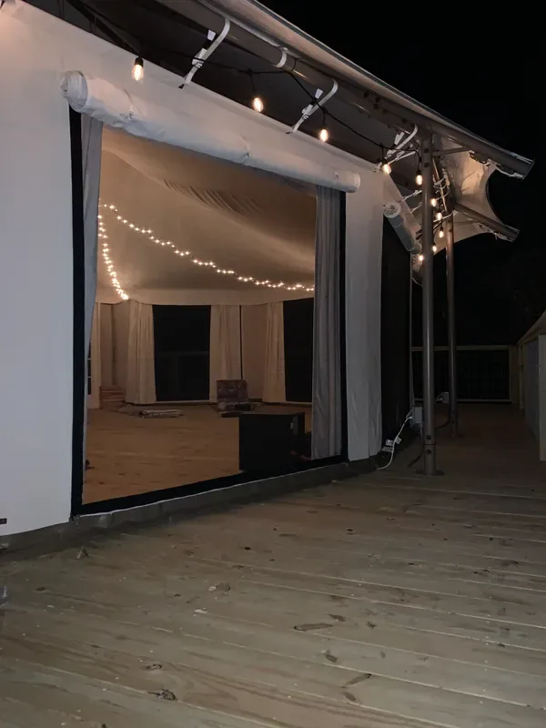Completed outdoor retreat deck illuminated at night.