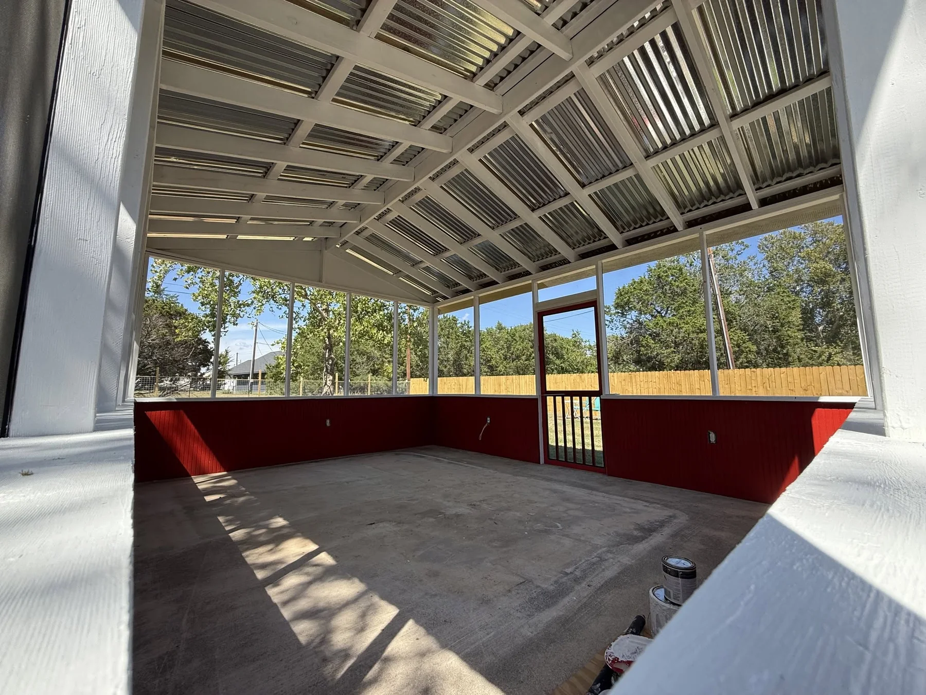 Finished custom sunroom interior with metal roof and screened window openings
